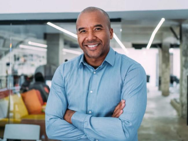 Man with his arms crossed smiling at the camera